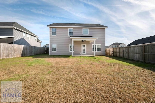 back of property with a yard, a patio, and ceiling fan