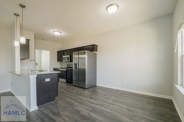 kitchen with kitchen peninsula, dark hardwood / wood-style flooring, sink, and stainless steel appliances