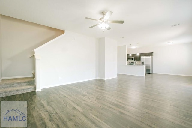 unfurnished living room with dark hardwood / wood-style floors and ceiling fan