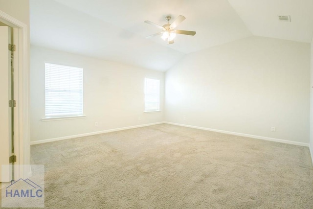 carpeted empty room with ceiling fan and lofted ceiling