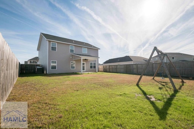 back of property featuring a lawn and a playground