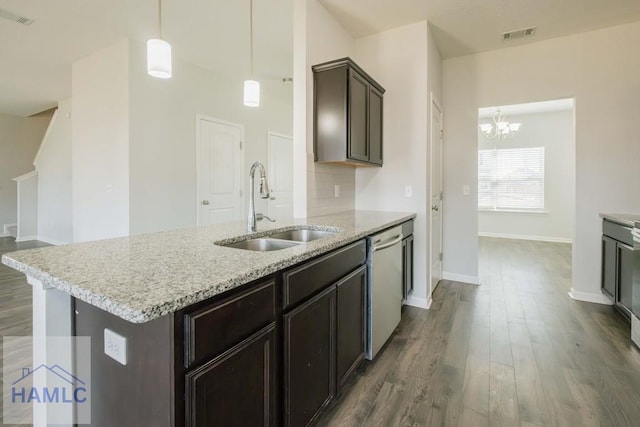 kitchen with a kitchen island with sink, dark wood-type flooring, sink, a notable chandelier, and dishwasher