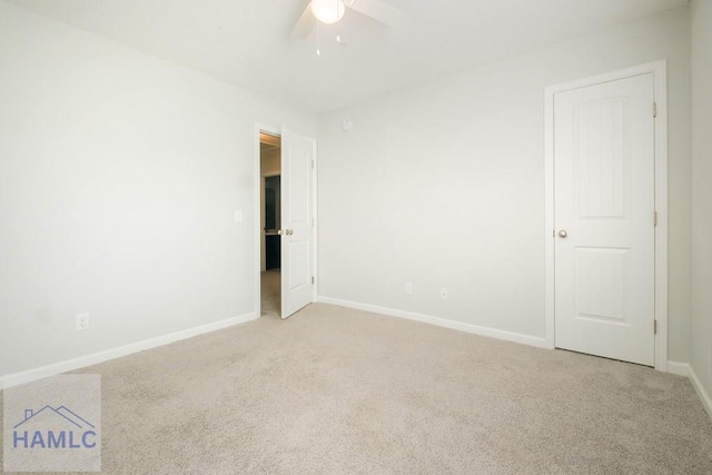 empty room featuring ceiling fan and light colored carpet