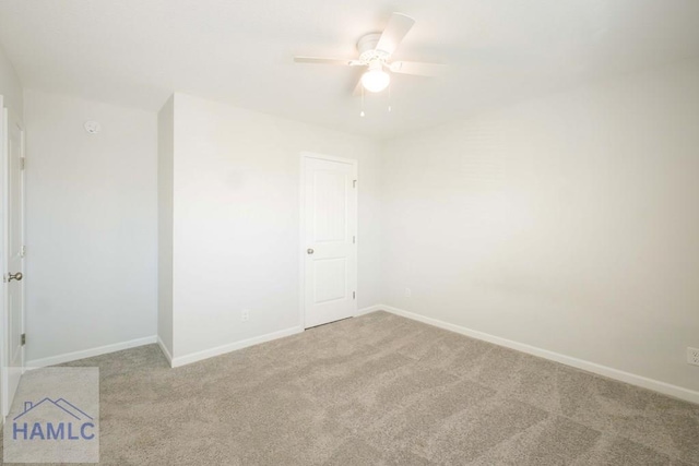 carpeted spare room featuring ceiling fan