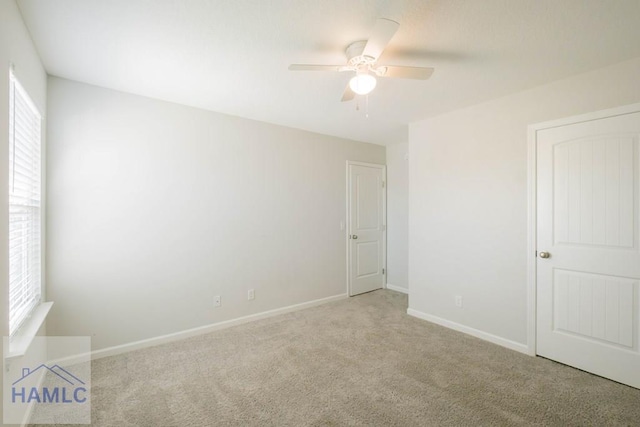 carpeted empty room featuring ceiling fan