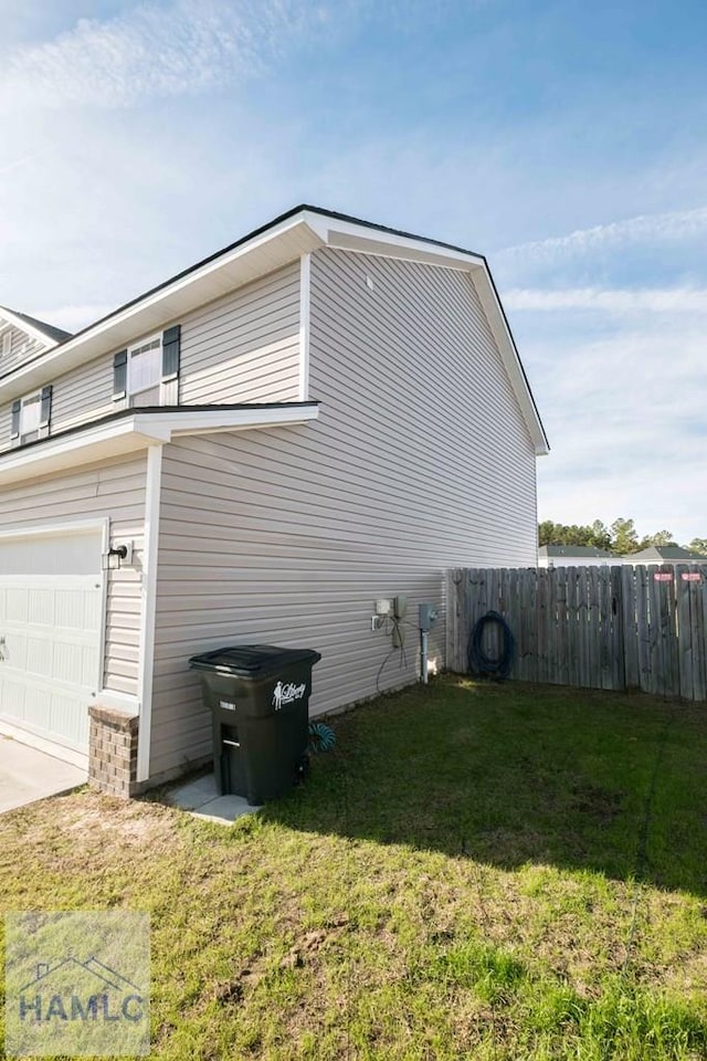 view of side of home featuring a yard and a garage