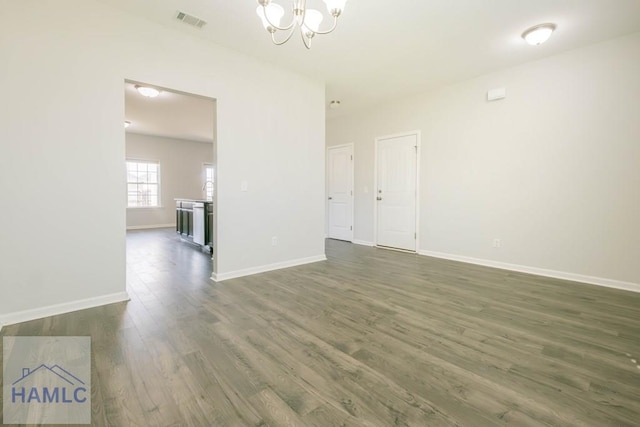 unfurnished room with dark hardwood / wood-style floors and a notable chandelier