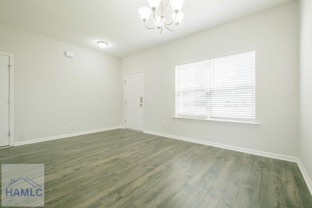 unfurnished room featuring dark hardwood / wood-style floors and a chandelier