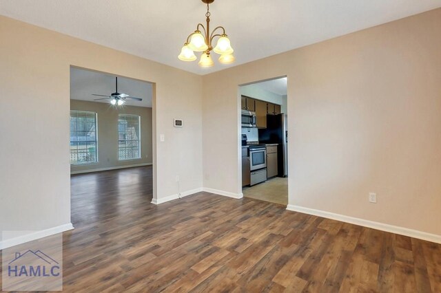 unfurnished dining area with ceiling fan with notable chandelier and dark hardwood / wood-style flooring