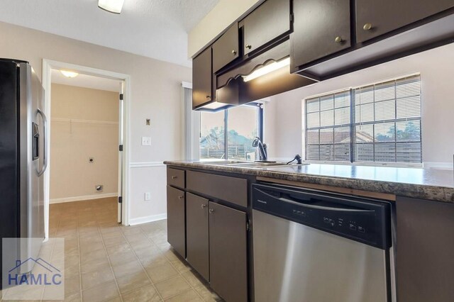 kitchen featuring light tile patterned flooring, appliances with stainless steel finishes, and sink