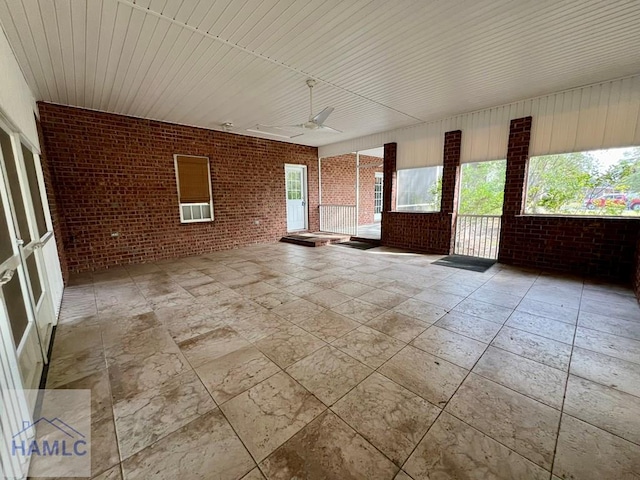 unfurnished sunroom with ceiling fan