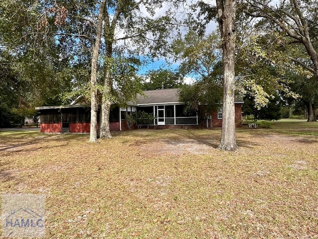 view of front of home featuring a sunroom and a front yard