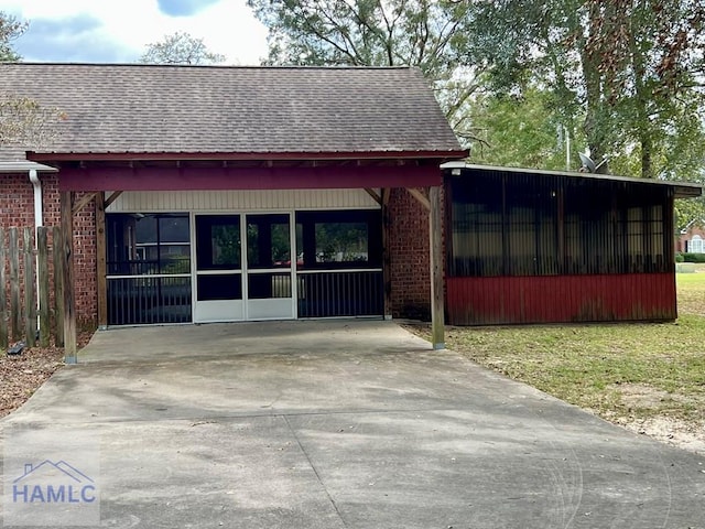 exterior space featuring a sunroom, a carport, and a front yard