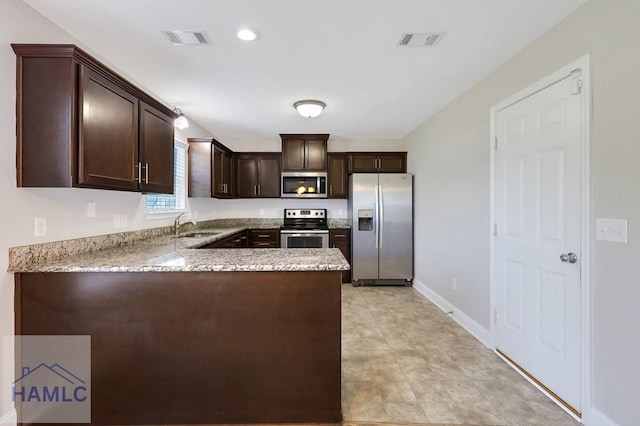 359 Nashview Trl, Allenhurst, GA 31301 - kitchen with stainless steel appliances, dark brown cabinetry, light stone countertops, and a sink
