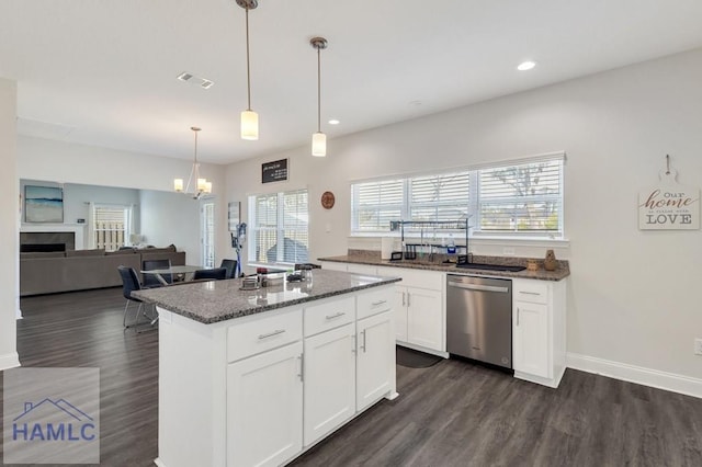 kitchen featuring dark stone countertops, visible vents, stainless steel dishwasher, and dark wood-style floors