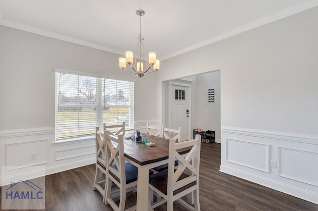 dining space featuring a wainscoted wall, wood finished floors, a chandelier, and crown molding