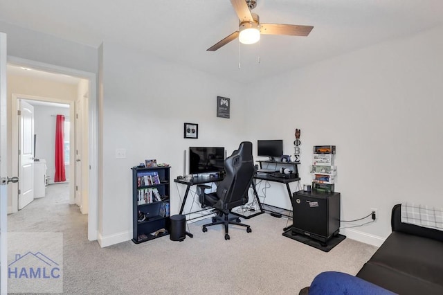 carpeted home office featuring baseboards and ceiling fan