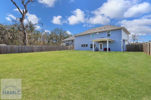 back of house with a yard and a fenced backyard