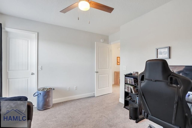 carpeted home office featuring baseboards and a ceiling fan