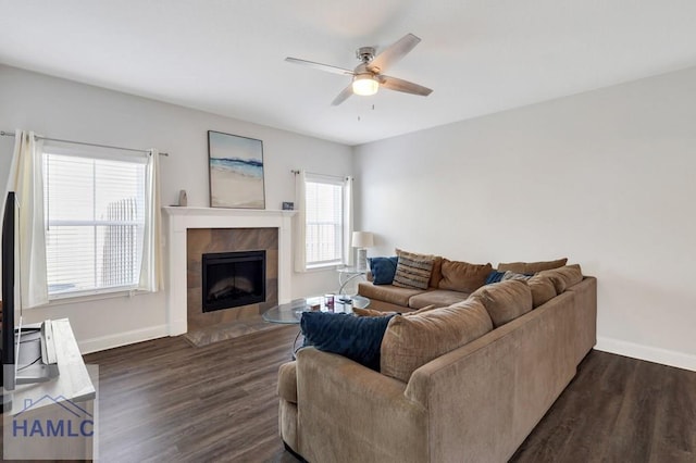 living room featuring a fireplace, dark wood-type flooring, and baseboards