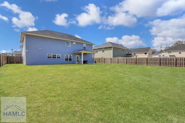 back of property featuring a lawn and a fenced backyard