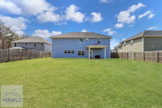 rear view of property with a yard and a fenced backyard