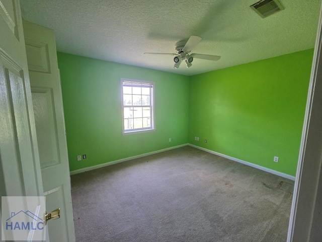 empty room with baseboards, carpet flooring, ceiling fan, and visible vents