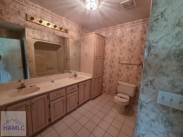 bathroom with wallpapered walls, a sink, a textured ceiling, and visible vents