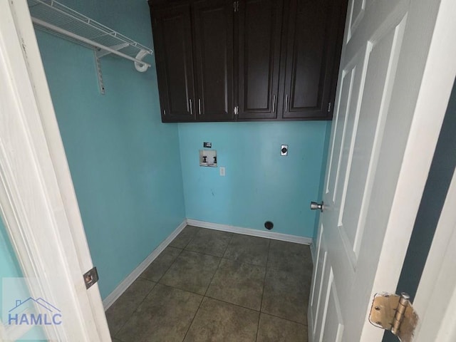 washroom with dark tile patterned floors, baseboards, cabinet space, electric dryer hookup, and washer hookup