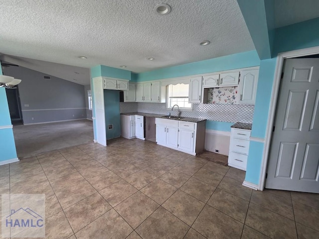 kitchen featuring white cabinetry, a sink, and tasteful backsplash