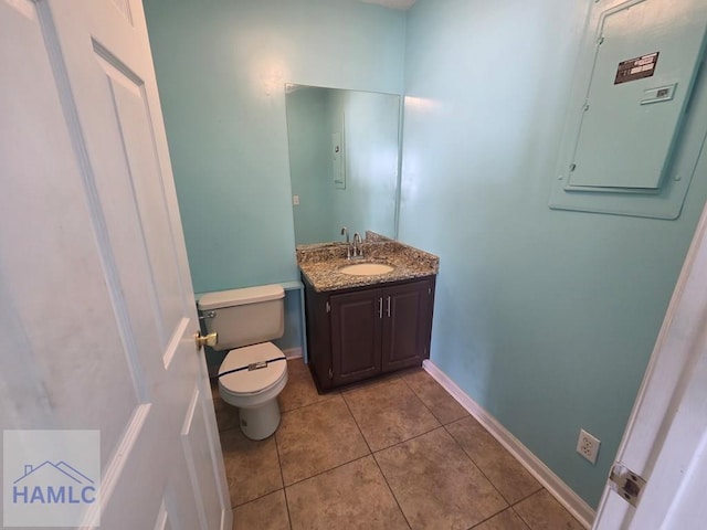 bathroom with electric panel, baseboards, toilet, tile patterned floors, and vanity