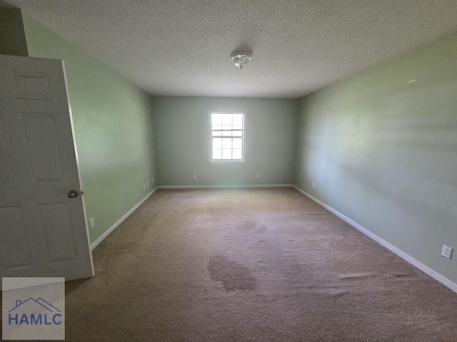 unfurnished room featuring baseboards, a textured ceiling, and light colored carpet
