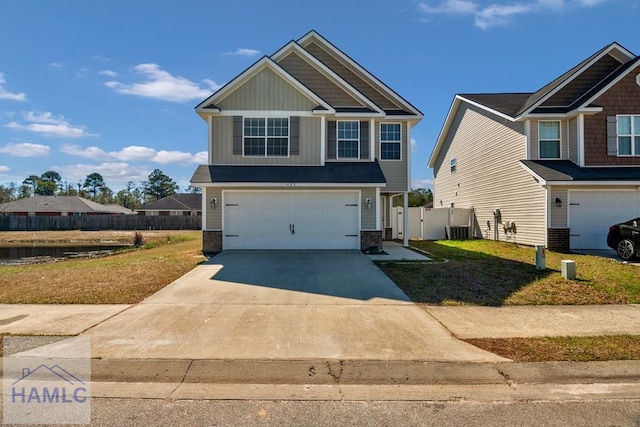 craftsman inspired home featuring driveway, an attached garage, fence, cooling unit, and board and batten siding