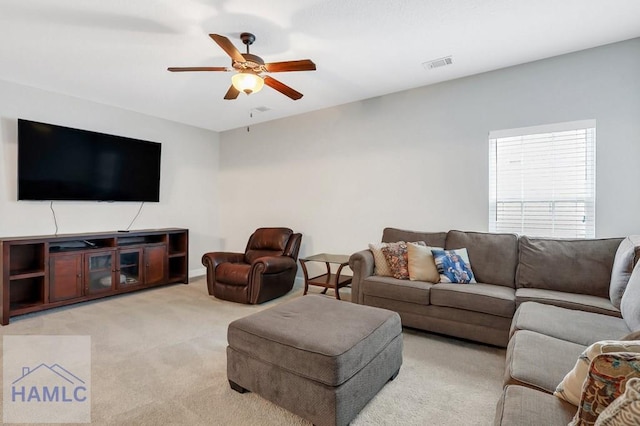 living area with light carpet, a ceiling fan, and visible vents