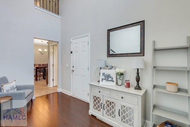 foyer with baseboards, an inviting chandelier, and dark wood-style floors