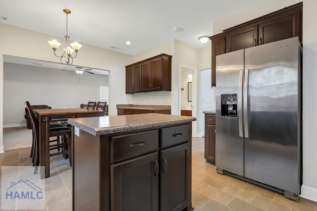 kitchen with dark brown cabinets, an inviting chandelier, stainless steel fridge with ice dispenser, decorative backsplash, and a kitchen island