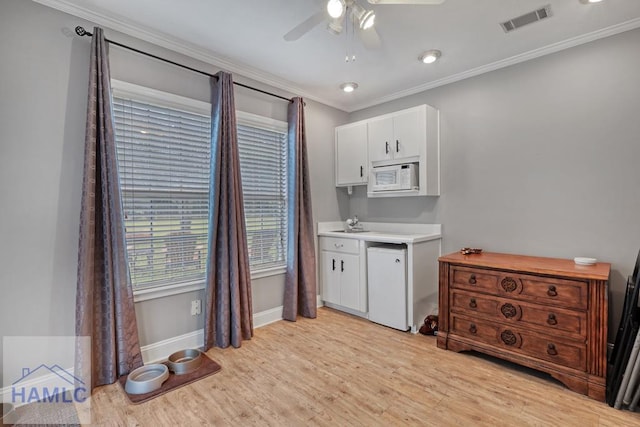 kitchen with white cabinetry, white appliances, ceiling fan, crown molding, and light wood-type flooring