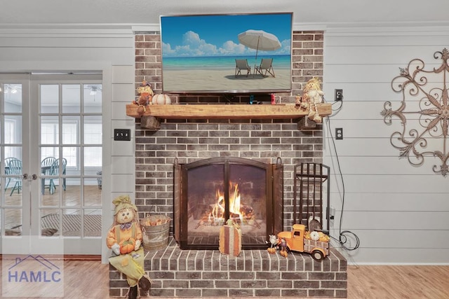 details featuring hardwood / wood-style flooring, ornamental molding, a fireplace, and wood walls