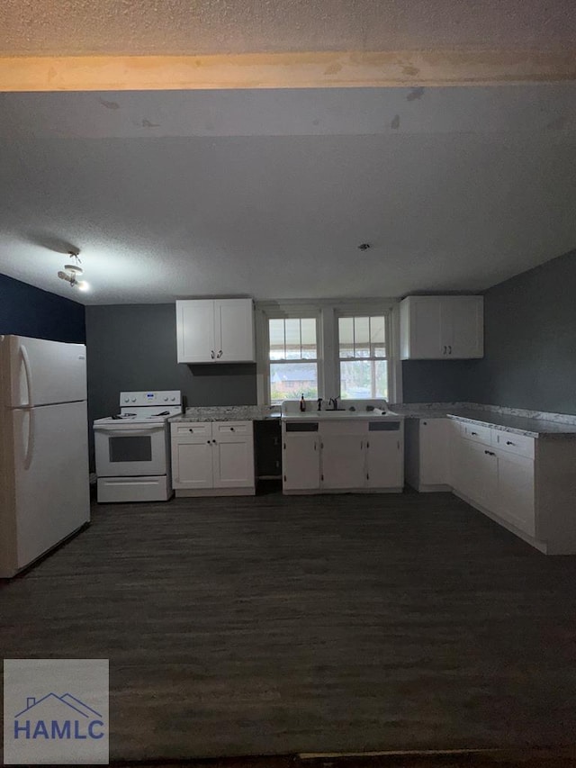 kitchen featuring dark hardwood / wood-style flooring, white appliances, white cabinetry, and a textured ceiling