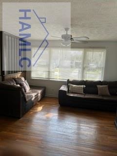 interior space featuring a textured ceiling, a ceiling fan, and wood finished floors