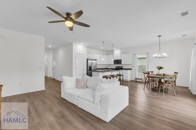 living area featuring recessed lighting, wood finished floors, and baseboards