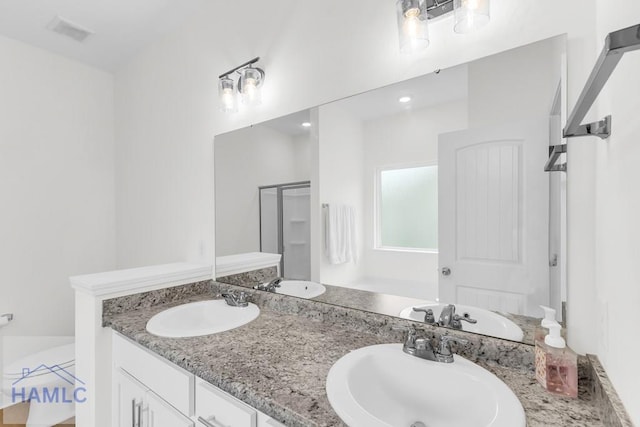 full bathroom with double vanity, visible vents, and a sink