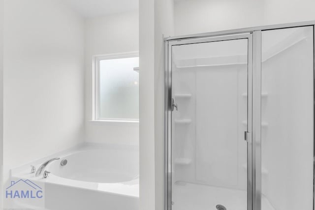 bathroom with a stall shower and a garden tub