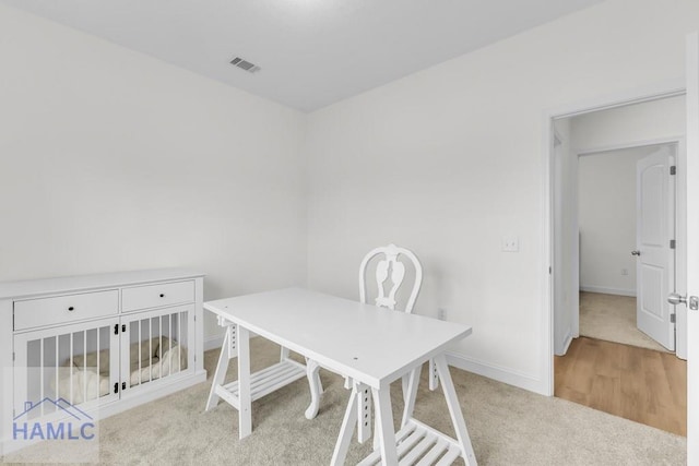 office area with light carpet, visible vents, and baseboards