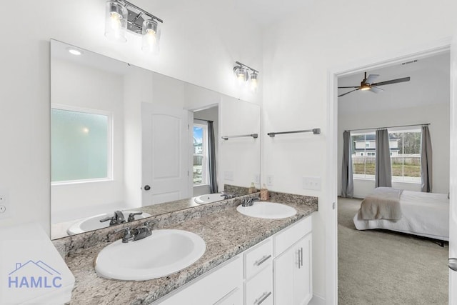 ensuite bathroom with double vanity, ensuite bath, and a sink