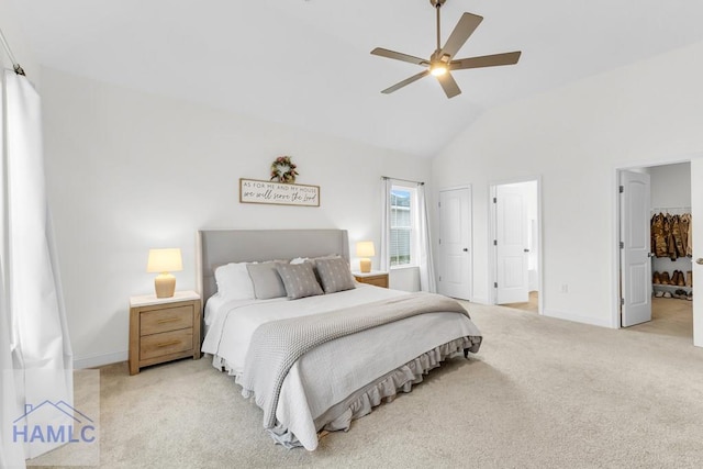 bedroom featuring ceiling fan, high vaulted ceiling, light carpet, baseboards, and ensuite bath