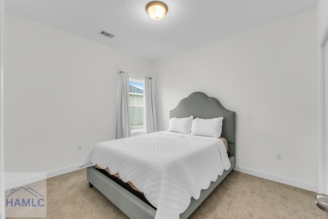 bedroom featuring visible vents, light carpet, and baseboards