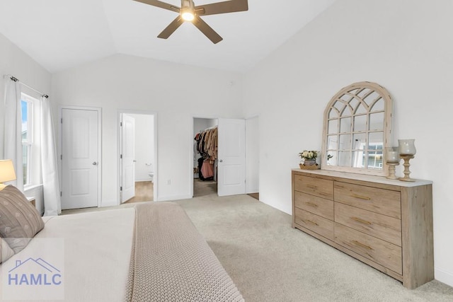 bedroom with a walk in closet, lofted ceiling, a closet, light colored carpet, and a ceiling fan