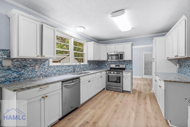 443 Martin Rd, Midway, GA 31320 - kitchen featuring appliances with stainless steel finishes, ornamental molding, a textured ceiling, decorative backsplash, and light wood-style floors