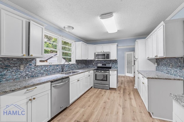 443 Martin Rd, Midway, GA 31320 - kitchen with stainless steel appliances, light wood finished floors, tasteful backsplash, a textured ceiling, and white cabinets